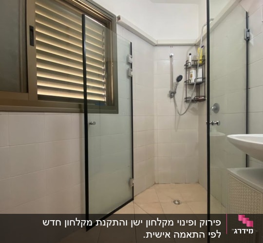מקלחון עם דלתות זכוכית ומדף עם מוצרי רחצה